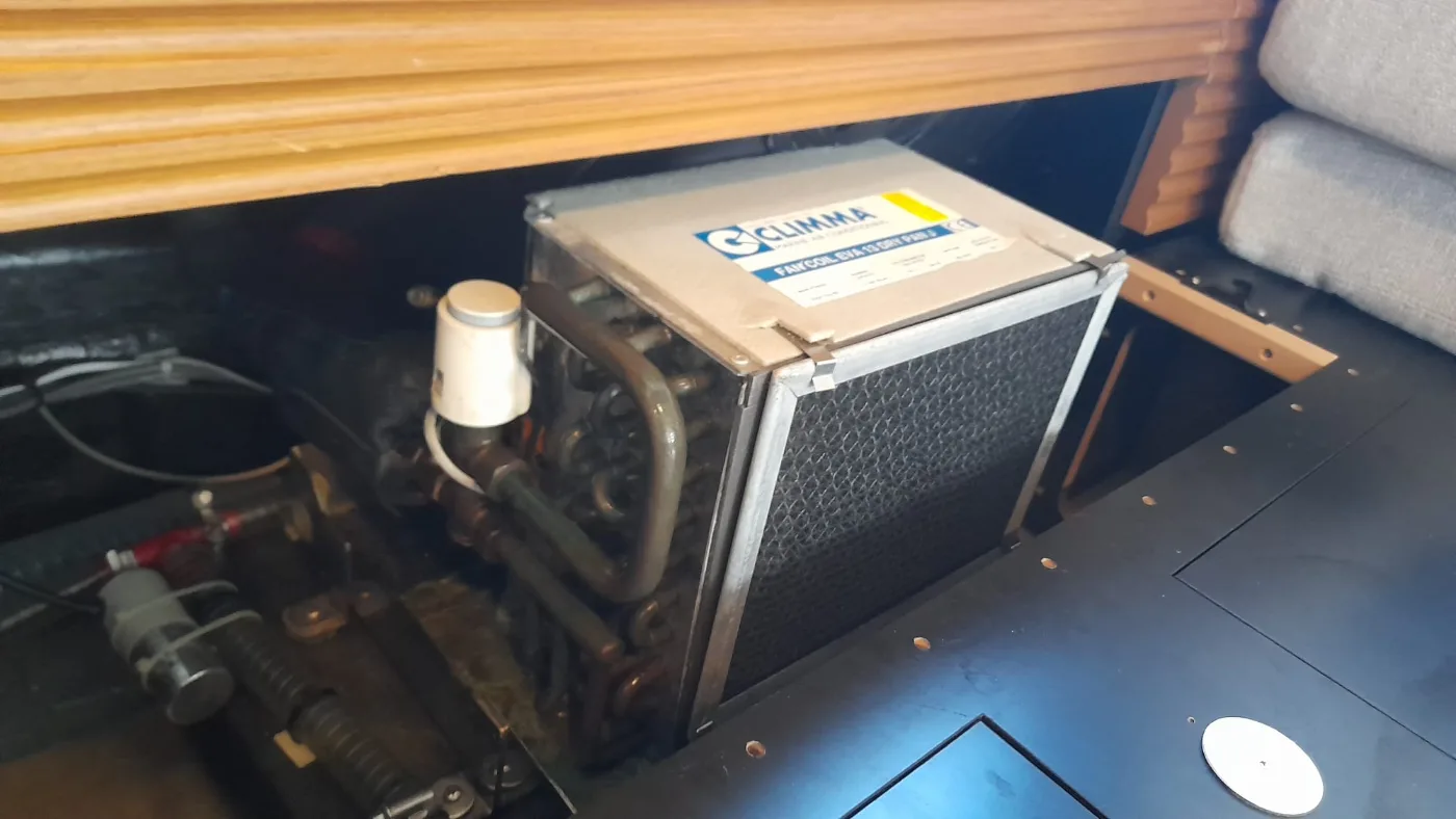 Marine fan coil unit exposed under cabin joinery, coil and filter visible