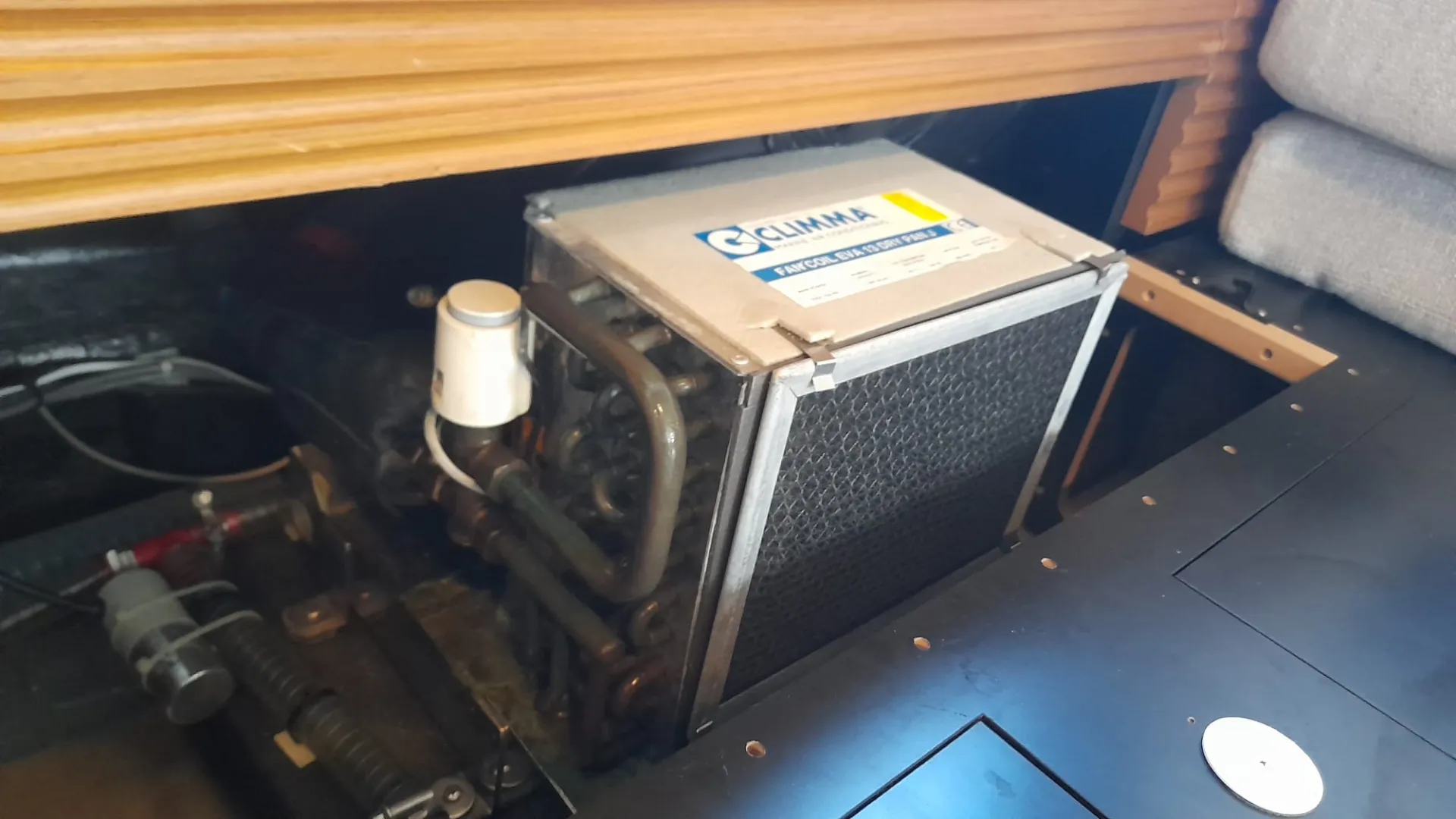 Marine fan coil unit with coil, valve and pipes visible during an AirBio Marine inspection
