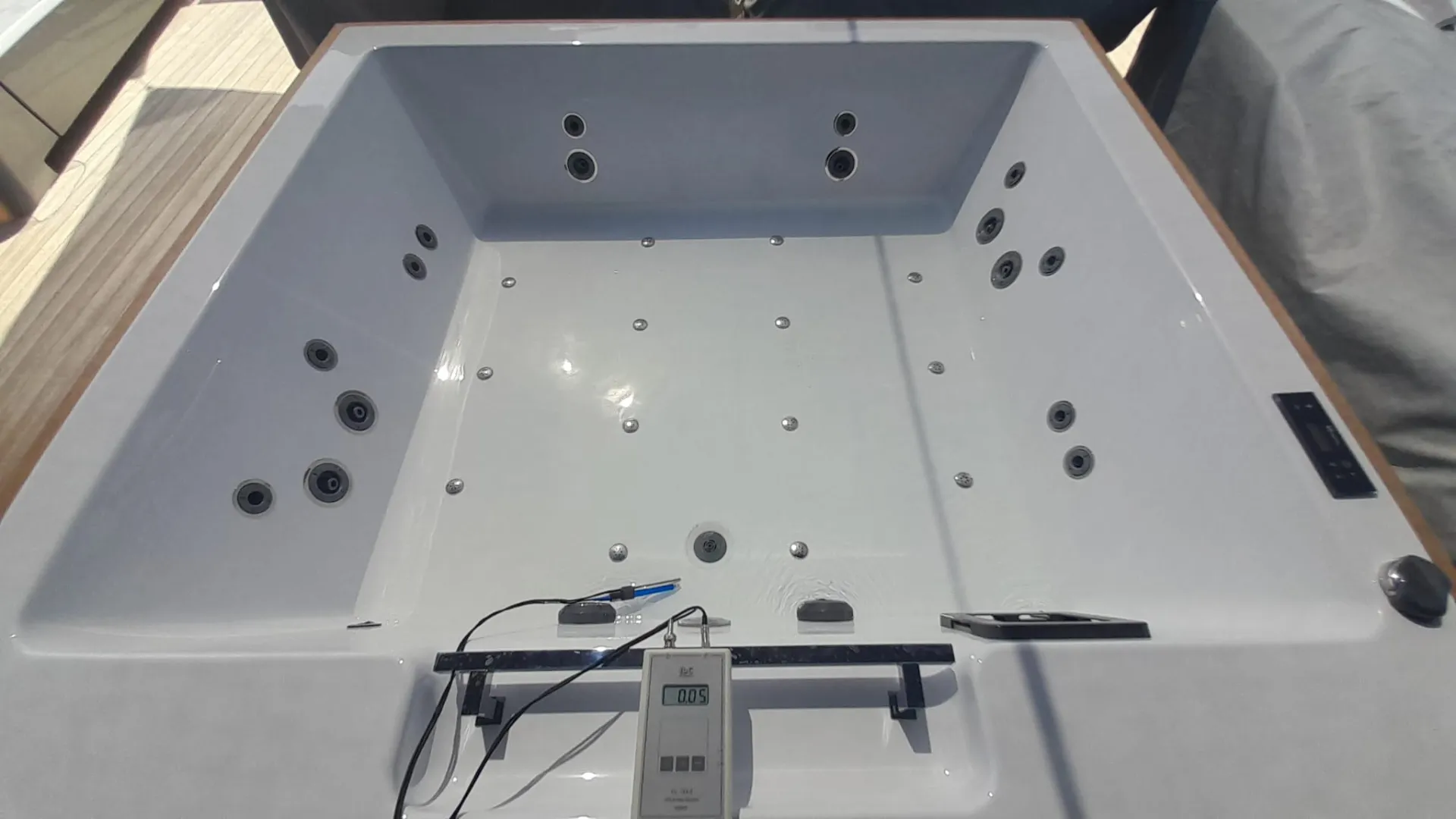 Deck jacuzzi on a yacht with a digital meter measuring the water after treatment