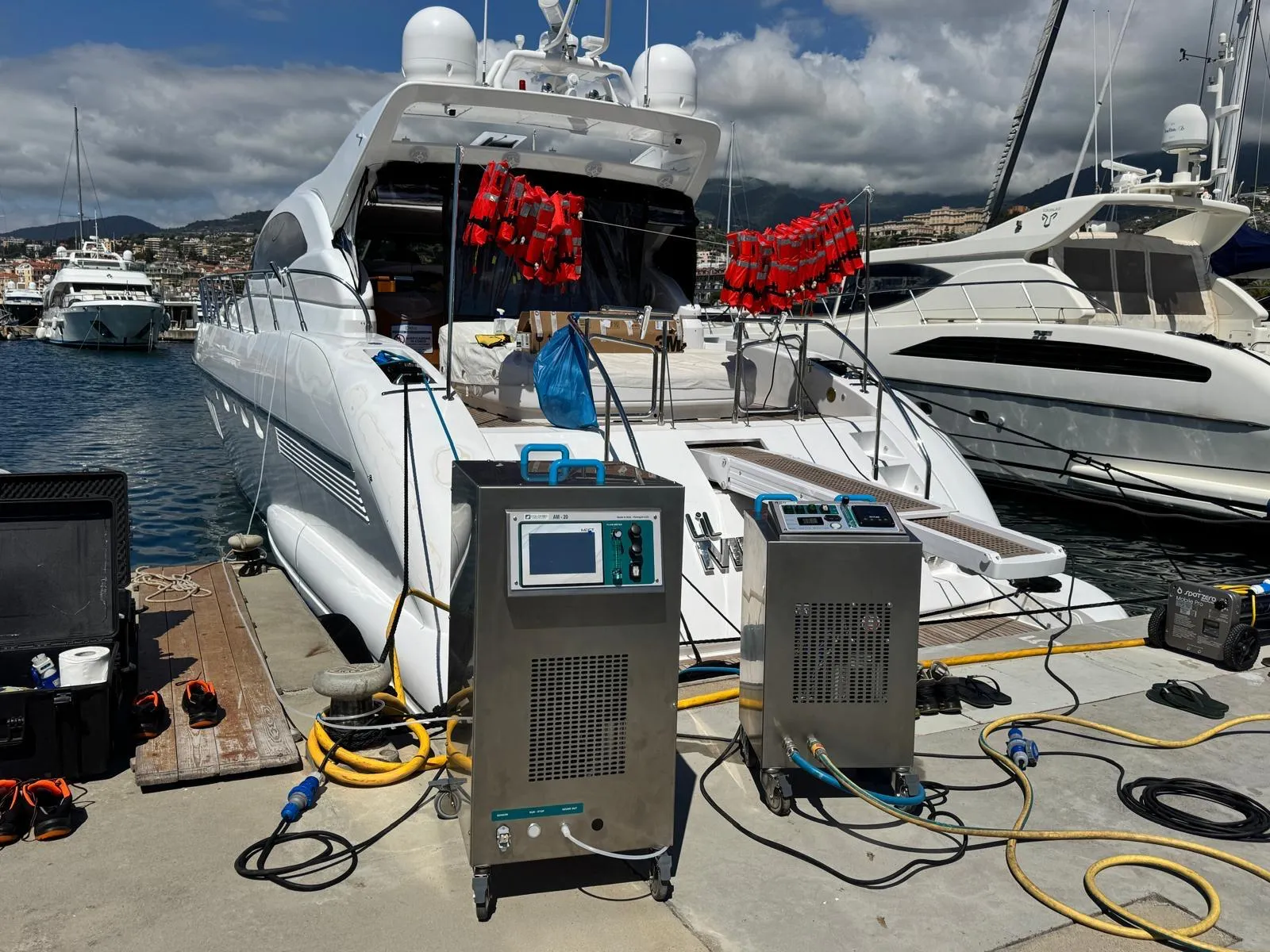 Mobile yacht sanitization equipment and technician kit on the quay next to a motor yacht
