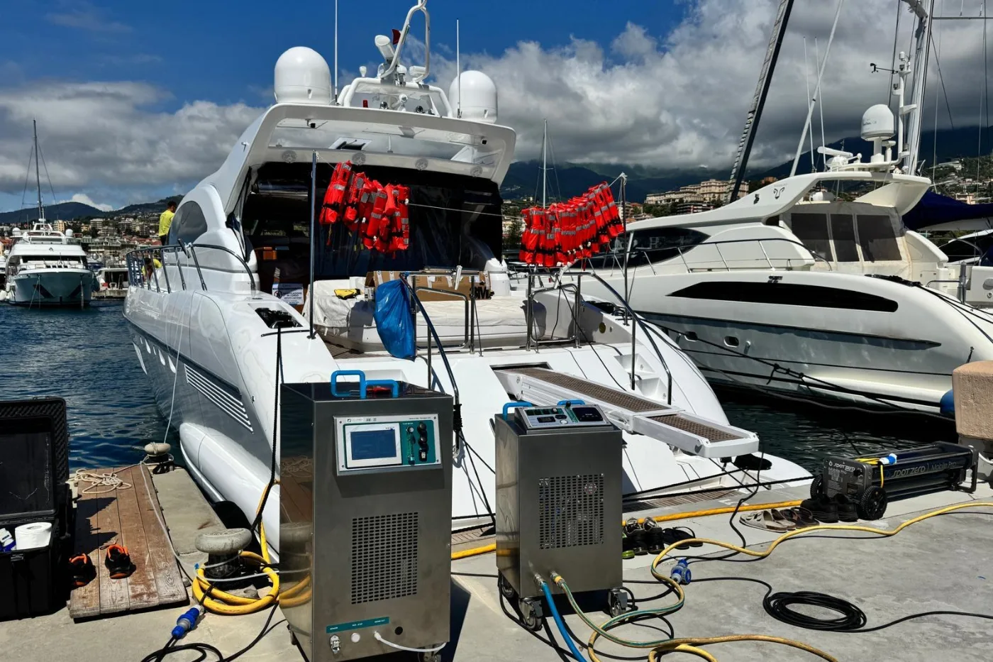 Two AirBio sanitization units on the quay with hoses running aboard a motor yacht